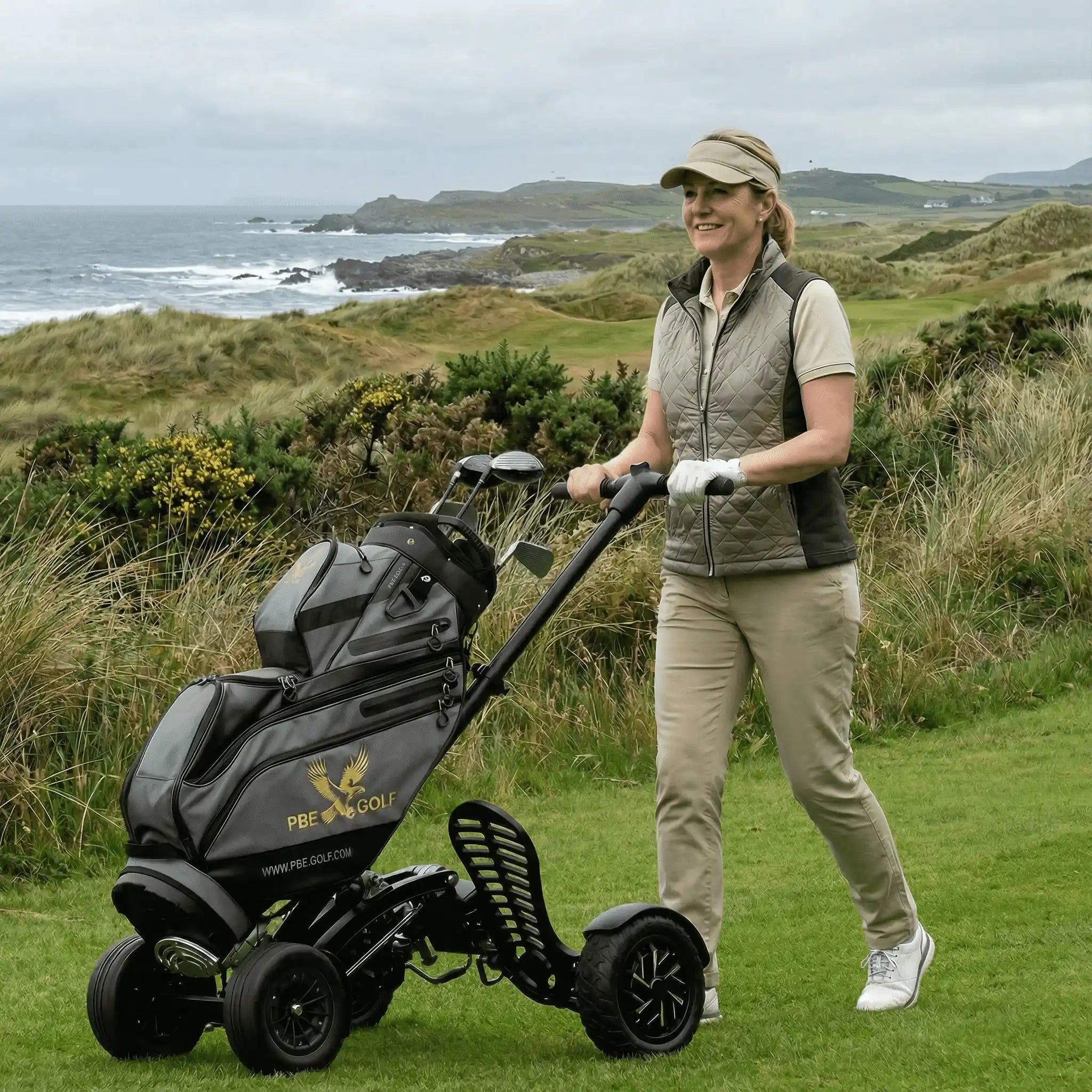 Woman pushing a golf cart on a golf course with ocean view