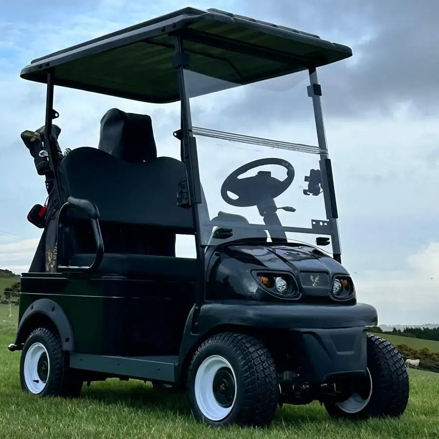 Golf cart on a grassy field with a blue sky and clouds in the background