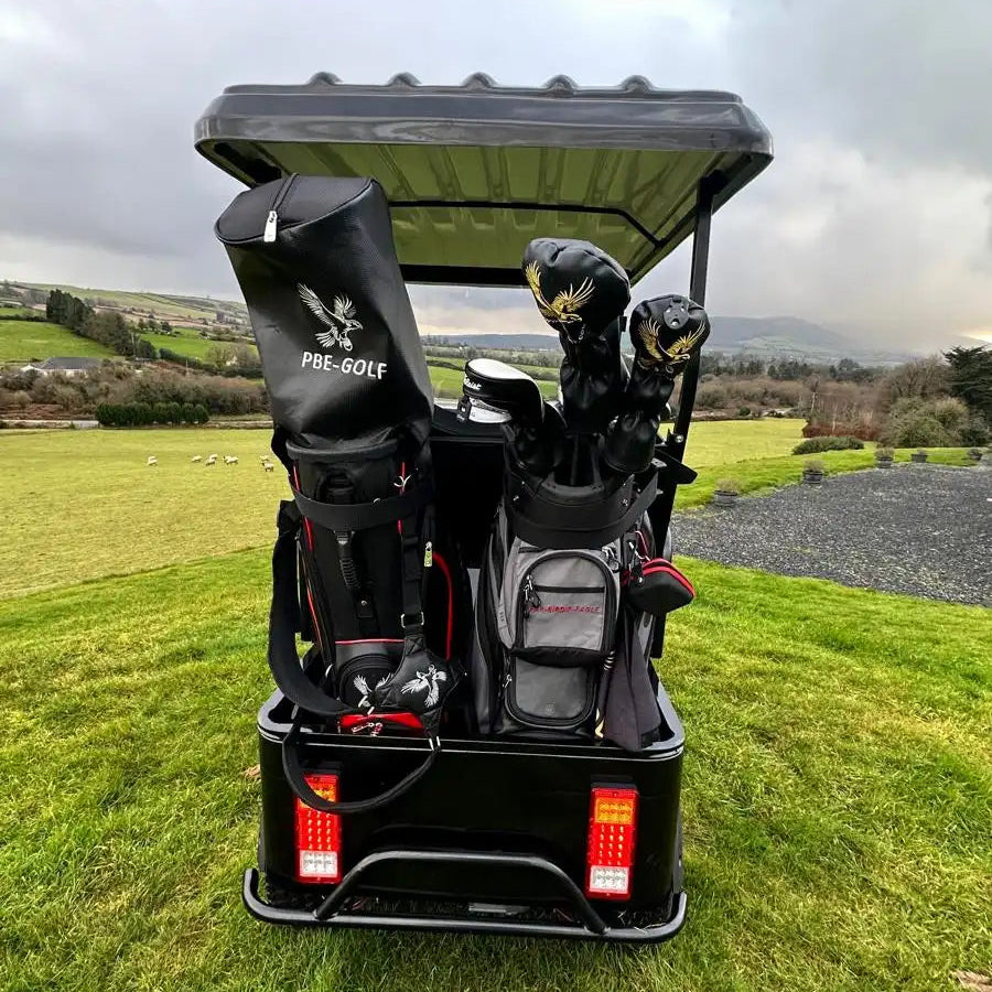 Golf cart with golf clubs on a grassy area